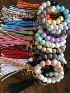 Macro shot of colorful silicone beaded wristlet keychains with leather tassels and gold clips