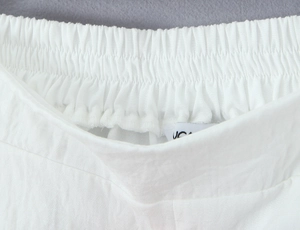 Dettaglio di pantaloni bianchi in cotone e lino con vita elastica e trama in tessuto morbido