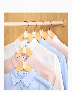 Vertical space-saving clothes hanger connector hooks shown in a wooden closet setting