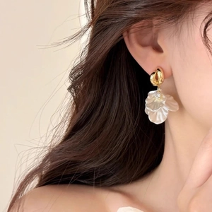 Close-up of elegant flower petal drop earrings with white shell texture and gold finish