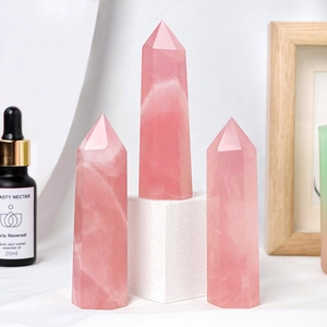 Natural rose quartz hexagonal crystal points displayed on a minimalist white surface