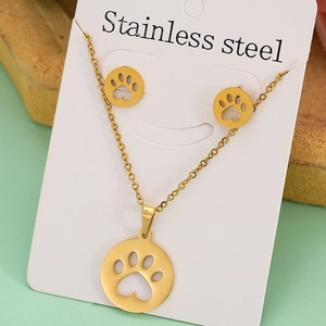 Detail of gold stainless steel jewelry set featuring hollow footprint design on white card