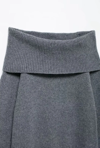 Close-up of dark grey chunky knit sweater collar showing textured rib stitching detail