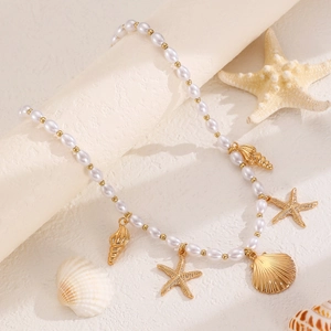 Boho-Halskette mit goldenen Muschel- und Seesternanhängern und weißen Perlen für den Strand