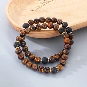 Detail of tiger eye and lava stone beaded bracelets with natural texture on a wooden tray