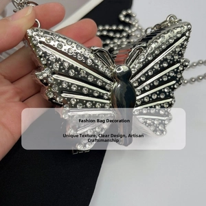 Detailed close-up of butterfly pendant featuring silver metal and sparkling rhinestones