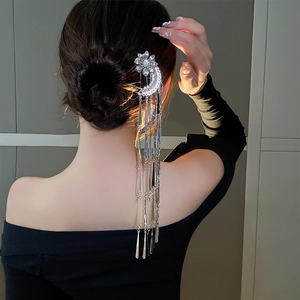 Silver flower tassel hair pin shown on a bun from behind to display the elegant hang