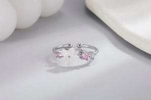 Macro detail of adjustable silver flower ring with shell cherry blossom and pink zircons
