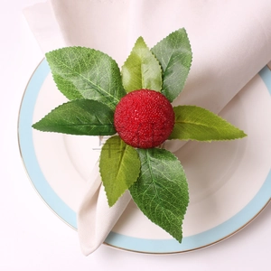 Macro shot of realistic orange berry napkin ring with green leaves on a white napkin
