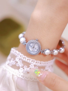 Close-up of elegant pearl bracelet watch with rhinestone bezel and roman numeral dial