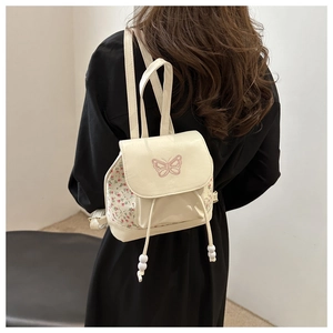 Off-white floral mini backpack with pink butterfly embroidery for women on a model