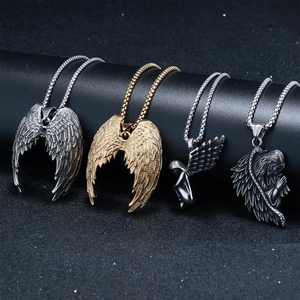Détail de pendentifs ailes d'ange en finitions or et argent sur supports cylindriques