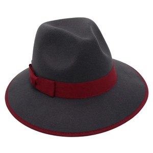 Detail of dark grey wool fedora hat with deep red ribbon bow and contrast bound edge