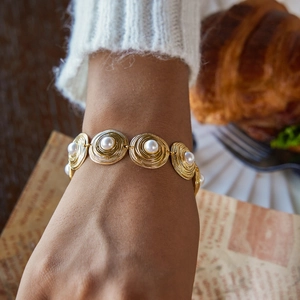 Elegant 18K gold plated stainless steel bracelet with textured discs and pearls on wrist