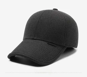 Detail view of the textured knit fabric and side label on a dark grey winter baseball cap