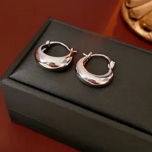 Polished silver U-shaped metal hoop earrings with a sleek mirror finish on a black gift box