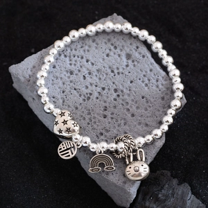 Silver beaded bracelet with rabbit, heart, and Fu character charms on volcanic stone