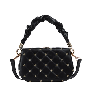 Quilted black handbag with golden flower studs and cloud-shaped handle on a white background