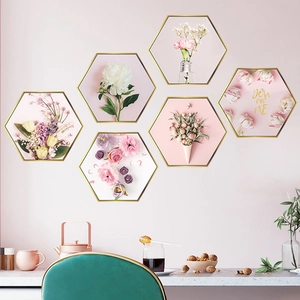 Dettaglio di adesivi murali floreali esagonali con fiori rosa e scritte oro su parete