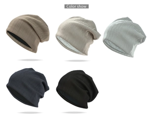 Détail de la texture tricotée de bonnets amples en kaki, beige, gris et noir classiques