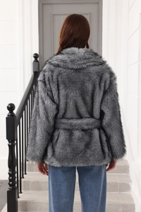 Back view of a grey faux fur mid-length coat with a matching waist belt on a model