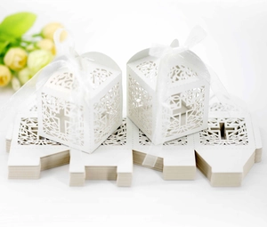 Flat pack and assembled white laser-cut cross favor boxes with white silk ribbons