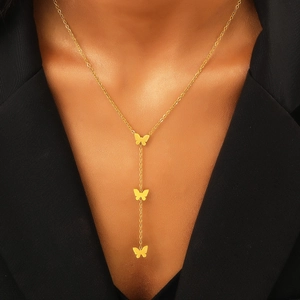 Vista dettagliata della collana a forma di Y con farfalle dorate su blazer nero