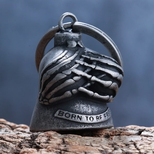 Macro shot of silver motorcycle bell pendant with skull hands and Born To Be Free text