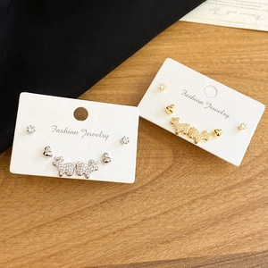Détail de parures de boucles d'oreilles argentées et dorées avec motifs chien en zircon