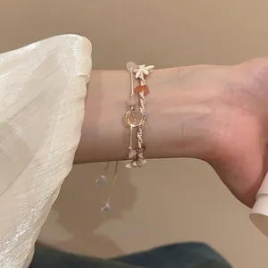 Böhmisches zweiteiliges Armbandset mit Natursteinen und Seesternanhängern am Handgelenk