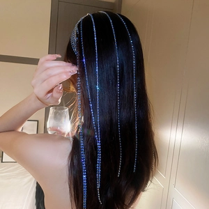 Detail of royal blue rhinestone tassel hair chain cascading over long dark hair