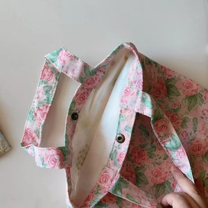 Detail of floral cotton tote bag with rose prints, metal snap button and canvas lining