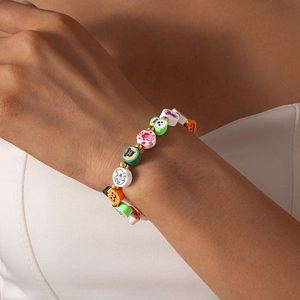 Detail of Halloween beaded bracelet featuring pumpkin and ghost charms on a female wrist