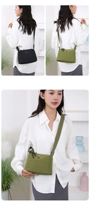 Sac bandoulière en nylon noir et vert porté par un mannequin pour voyage et loisirs