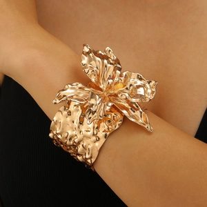 Detailansicht eines goldenen Blumen-Armreifs mit gehämmerter Wellentextur am Modell