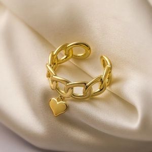 Minimalist 18K gold plated chain ring with a dangling heart pendant on silk fabric