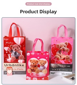 Close-up of three pink and red Valentine heart balloon bear non-woven gift bags on a table