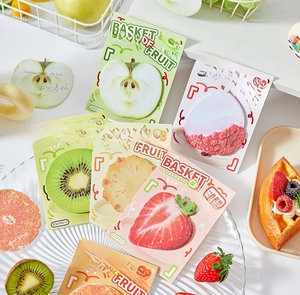 Creative fruit-shaped sticky notes including apple and strawberry on a decorative table