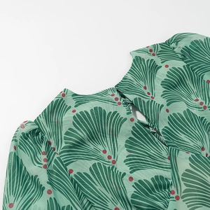Close-up of green leaf floral print chiffon dress with cutout lace-up neckline detail