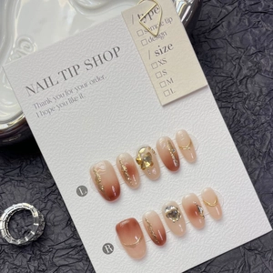 Faux ongles faits main marron ambré avec feuille d'or et accents de pierres précieuses