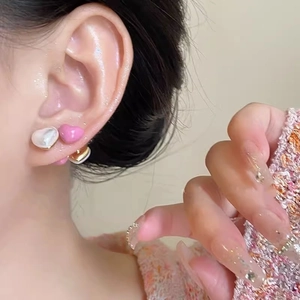 Sweet pink enamel and pearl heart stud earrings on model for a trendy look