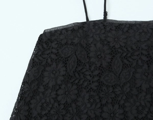 Dettaglio del pizzo floreale nero e del design a rete traforata sulla canotta trendy