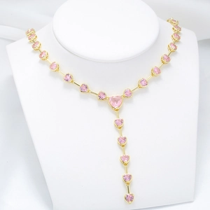 Detail of elegant gold-toned Y-necklace featuring pink heart-shaped crystal gemstones