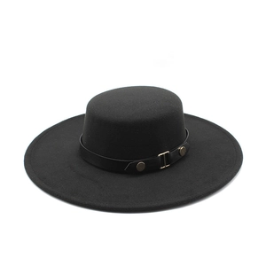 Detail of black flat top wool hat with leather band and gold buckle in vintage style