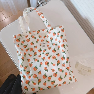 Detail der weißen Stofftasche mit orangefarbenem Tulpendruck und ästhetischem Webeetikett