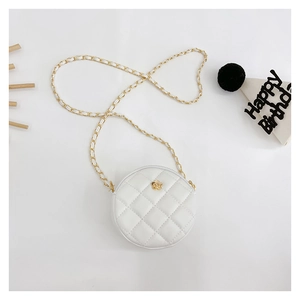 Close-up of a white quilted round bag with gold flower buckle and leather chain strap