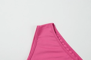 Vue macro du tissu tricot fuchsia montrant la couture à double aiguille et la finition