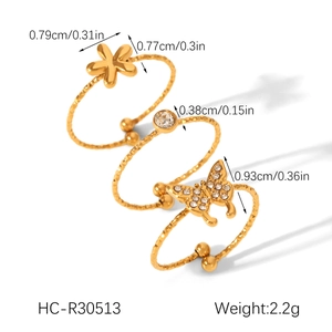 Detailed set of three adjustable gold-toned rings with flower and butterfly zircon pendants