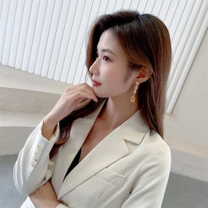 Detailed close-up of elegant long drop earrings with yellow zircon on a female model