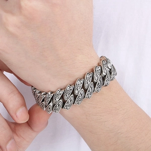 Close-up of vintage Cuban chain bracelet with intricate engraved patterns on wrist
